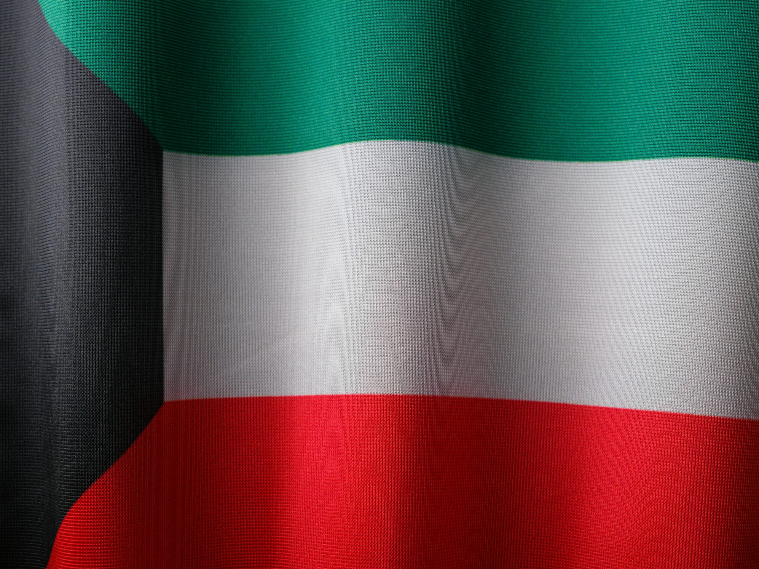 A detailed close-up of Kuwait's national flag with vibrant colors and gentle waves, symbolizing patriotism.